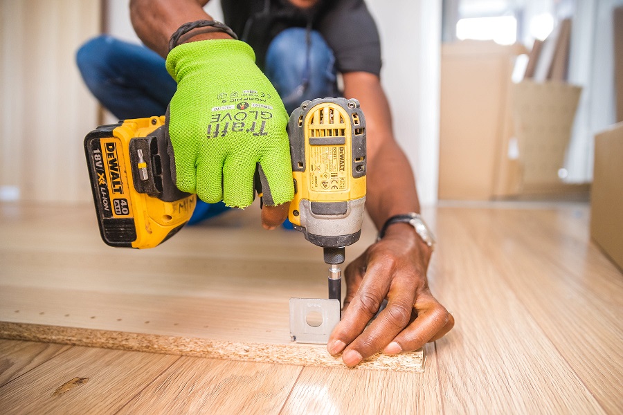 construction worker drilling a hole with a power tool